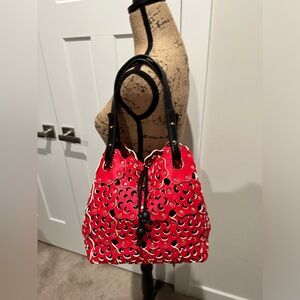 Red Perforated Shoulder bag with Black Handles and drawstring insert